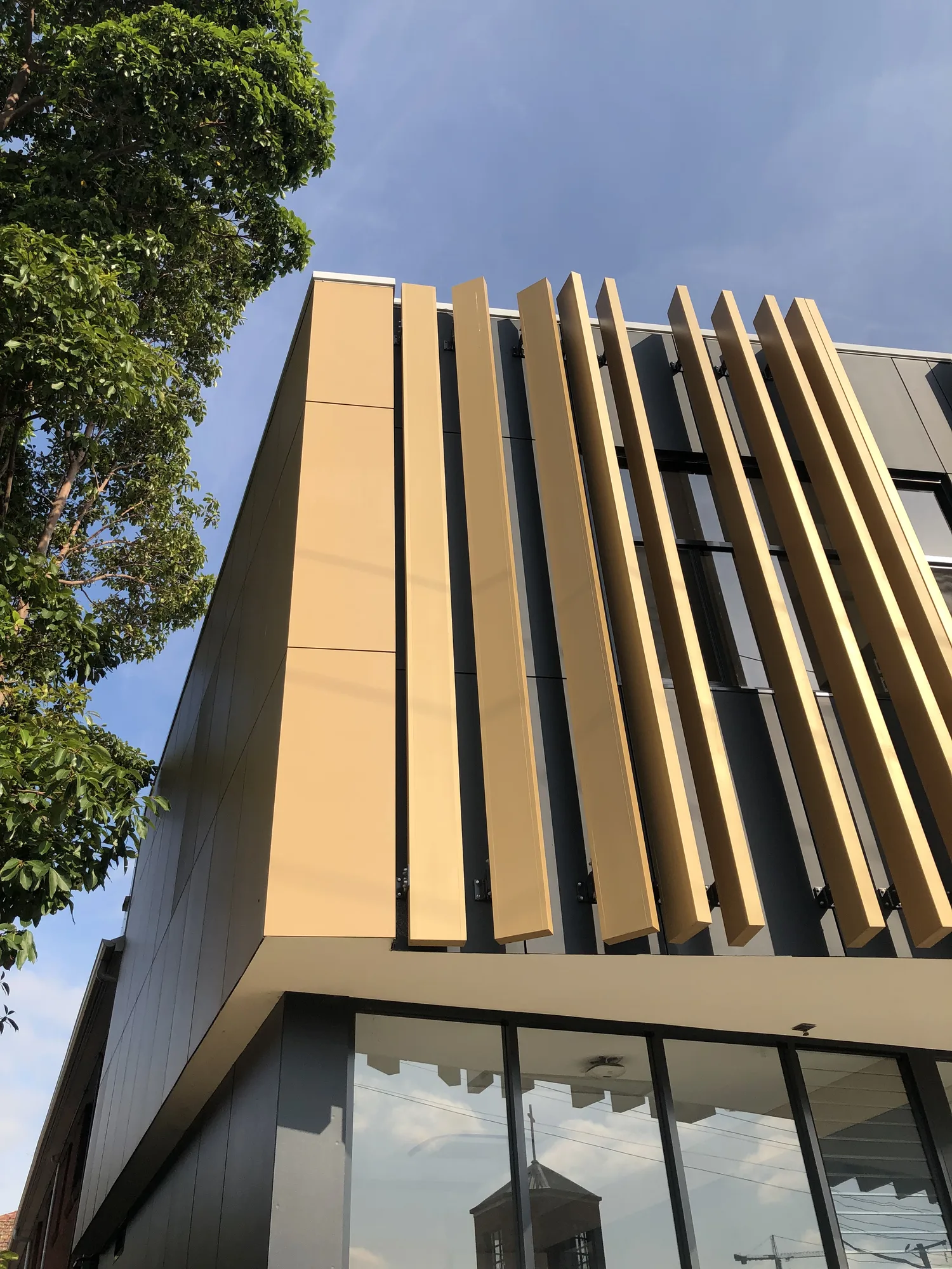 Corner of the new building, fins rising above full-height glazing