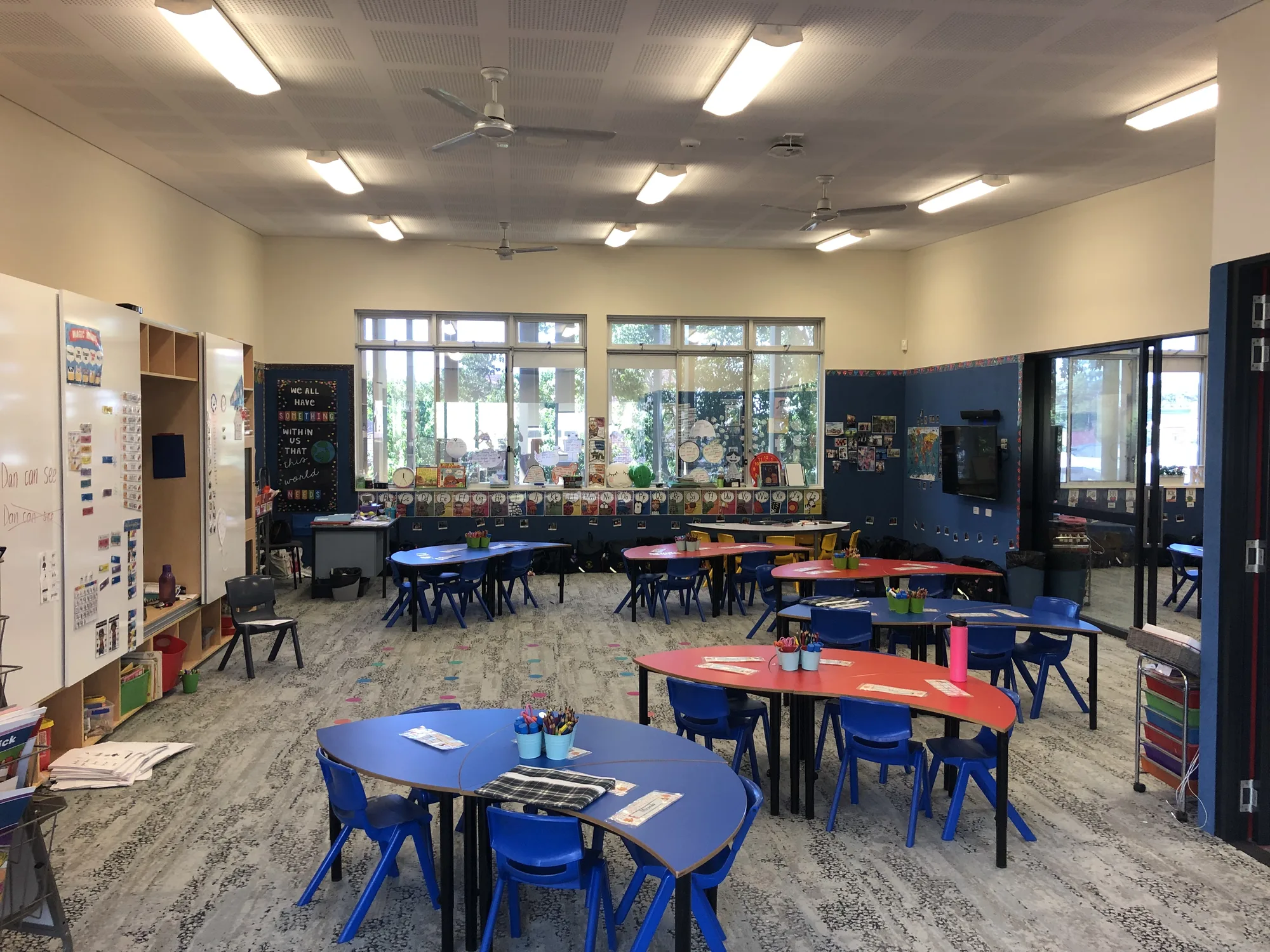 A refurbished classroom with group tables, writable walls and an open outlook